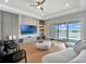 Modern living room with a sleek entertainment center, sliding glass doors to the outside, and comfortable seating at 16808 Bolsena Dr, Bella Collina, FL 34756