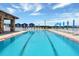 Beautiful swimming pool with lounge chairs and umbrellas, set against a bright blue sky at 16808 Bolsena Dr, Bella Collina, FL 34756