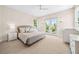Neutral bedroom with light gray bed, access to balcony, and light filled windows at 1700 Palm Ave, Winter Park, FL 32789