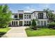 Contemporary two-story home featuring a modern design, manicured landscaping, and a spacious driveway at 1700 Palm Ave, Winter Park, FL 32789