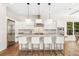 Sleek kitchen featuring white cabinets, stainless steel appliances, hardwood floors, and island with seating at 1700 Palm Ave, Winter Park, FL 32789