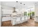 Bright kitchen with white cabinetry, stainless steel appliances, an island with seating, and hardwood floors at 1700 Palm Ave, Winter Park, FL 32789