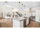 Open-concept kitchen and living area with hardwood floors, modern appliances, and a cozy fireplace at 1700 Palm Ave, Winter Park, FL 32789