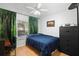 Cozy bedroom with a wood floor, ceiling fan, and ample natural light from the window at 1848 Jimson Ave, Ocoee, FL 34761