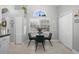 Sunlit dining area with a glass table, velvet chairs, and views from a large arched window at 1848 Jimson Ave, Ocoee, FL 34761