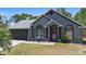 Charming single-story home features a well-manicured lawn, gray exterior, a red front door, and an attached two-car garage at 1848 Jimson Ave, Ocoee, FL 34761