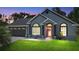 Charming single-story home featuring a red front door, a well-manicured lawn, and a two-car garage at 1848 Jimson Ave, Ocoee, FL 34761