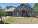 Charming single-story home featuring a red front door, a well-manicured lawn, and a two-car garage at 1848 Jimson Ave, Ocoee, FL 34761