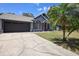 Charming single-story home with an extra-long driveway leading to a two-car garage with an appealing facade at 1848 Jimson Ave, Ocoee, FL 34761