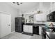 Bright kitchen featuring white cabinets, black appliances, wood-look tile floors, and modern fixtures at 1848 Jimson Ave, Ocoee, FL 34761