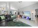 Spacious living room with a black sofa, area rug and natural light at 1848 Jimson Ave, Ocoee, FL 34761