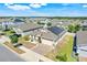 Aerial view featuring solar panels, a paved driveway, and well-maintained landscaping in a vibrant neighborhood at 210 Hydra Way, Groveland, FL 34736