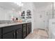 Elegant bathroom featuring a double vanity with granite countertops, wood-look floors, and a glass-enclosed shower at 210 Hydra Way, Groveland, FL 34736
