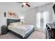 Cozy bedroom with carpeted floors, a dark-frame bed and nightstand, and a bright window with sheer curtains at 210 Hydra Way, Groveland, FL 34736
