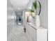 Bright hallway featuring marble floors, a stylish round mirror, and elegant decor with a view to the living room at 210 Hydra Way, Groveland, FL 34736