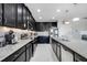 Modern kitchen with stainless steel appliances, granite countertops, and black cabinetry at 210 Hydra Way, Groveland, FL 34736