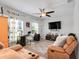 Cozy living room with large windows, comfortable reclining sofa, ceiling fan, and media center at 210 Hydra Way, Groveland, FL 34736