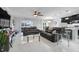 Bright, open-concept living room featuring marble floors, neutral decor, and seamless flow into the kitchen and dining area at 210 Hydra Way, Groveland, FL 34736