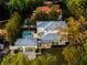 Aerial view of a home showcasing its pool, covered patio, and spacious yard within a lush, green neighborhood at 2171 Forrest Rd, Winter Park, FL 32789