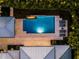 Aerial view of backyard pool featuring a built-in fire feature and surrounded by well manicured hedges and lounge chairs at 2171 Forrest Rd, Winter Park, FL 32789