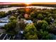 Sunset aerial of home with lake views, surrounded by mature trees and lush landscaping in a vibrant neighborhood at 2171 Forrest Rd, Winter Park, FL 32789