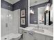 Stylish bathroom with a glass-enclosed shower, coastal artwork and marble vanity at 2171 Forrest Rd, Winter Park, FL 32789