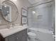 Bathroom featuring a shower and bath, sleek grey vanity and round mirror at 2171 Forrest Rd, Winter Park, FL 32789