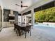 Outdoor kitchen with stone, wood ceiling, modern appliances and dining with pool views at 2171 Forrest Rd, Winter Park, FL 32789