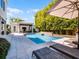 Backyard pool with waterfall feature, adjacent cabana, landscaping, and lounge chairs at 2171 Forrest Rd, Winter Park, FL 32789