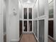 Custom designed walk-in closet with frosted glass doors, recessed lighting, and hardwood floors at 2171 Forrest Rd, Winter Park, FL 32789