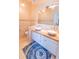 Well-lit bathroom with double sinks, a large mirror, and modern fixtures over blue rug at 225 Loma Del Sol Dr, Davenport, FL 33896