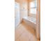 Bright bathroom featuring tiled floors and walls plus a soaking tub under a frosted window at 225 Loma Del Sol Dr, Davenport, FL 33896
