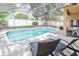 Inviting screened-in pool area with lounge chairs, patio, and privacy fence at 225 Loma Del Sol Dr, Davenport, FL 33896