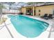 Relaxing pool area with an outdoor kitchen, lounge area, and pristine blue water at 225 Loma Del Sol Dr, Davenport, FL 33896
