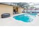 Picturesque pool area with a hot tub, outdoor seating, and a screened-in enclosure at 225 Loma Del Sol Dr, Davenport, FL 33896