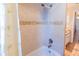Tiled bathtub and shower featuring a showerhead with a decorative accent at 225 Loma Del Sol Dr, Davenport, FL 33896