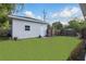 Large grassy backyard with a light blue shed and a dark wood fence at 24 W King St, Orlando, FL 32804