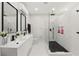 Modern bathroom features a walk-in shower with black fixtures and a double vanity with matching black hardware at 24 W King St, Orlando, FL 32804