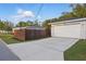 Long concrete driveway to a home with a detached garage and a wooden fence at 24 W King St, Orlando, FL 32804