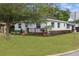 Charming home featuring a well-manicured lawn and inviting front yard with a wooden porch at 24 W King St, Orlando, FL 32804