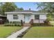 Charming home featuring a well-manicured lawn and inviting front yard with a light-blue front door at 24 W King St, Orlando, FL 32804