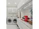 Laundry room with white cabinetry, granite countertops, washer and dryer, and tile floors at 24 W King St, Orlando, FL 32804