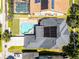 An aerial view of the property features a pool with spa, a large backyard, solar panels and an attached garage at 2424 Antlia Dr, Orlando, FL 32828