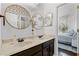 Bathroom showcasing double sinks, gold-framed mirrors, and a peek into a sunlit bedroom through an open door at 2424 Antlia Dr, Orlando, FL 32828