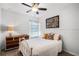 Bright bedroom featuring a white metal bed frame, dresser with lamp, and colorful decorative pillows at 2424 Antlia Dr, Orlando, FL 32828
