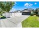 Driveway and fenced backyard view featuring solar panels and a black garage door offering privacy and energy efficiency at 2424 Antlia Dr, Orlando, FL 32828