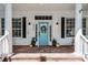 Inviting front porch with brick pavers, columns, blue door, and decorative plants at 2424 Antlia Dr, Orlando, FL 32828