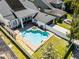 Aerial view showcasing a pool with hot tub, lounge areas, and backyard of the home featuring a lush lawn at 2424 Antlia Dr, Orlando, FL 32828
