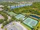 Aerial view of tennis courts surrounded by lush greenery and serene lakes at 2424 Antlia Dr, Orlando, FL 32828