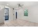 Well-lit bedroom featuring a tiled floor, ceiling fan and a barn door to an ensuite bathroom at 2623 Parsley Dr, Orlando, FL 32837